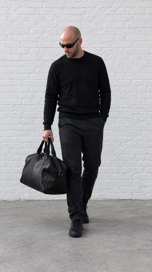 Originalfoto: Mann mit Tasche vor weißer Wand
